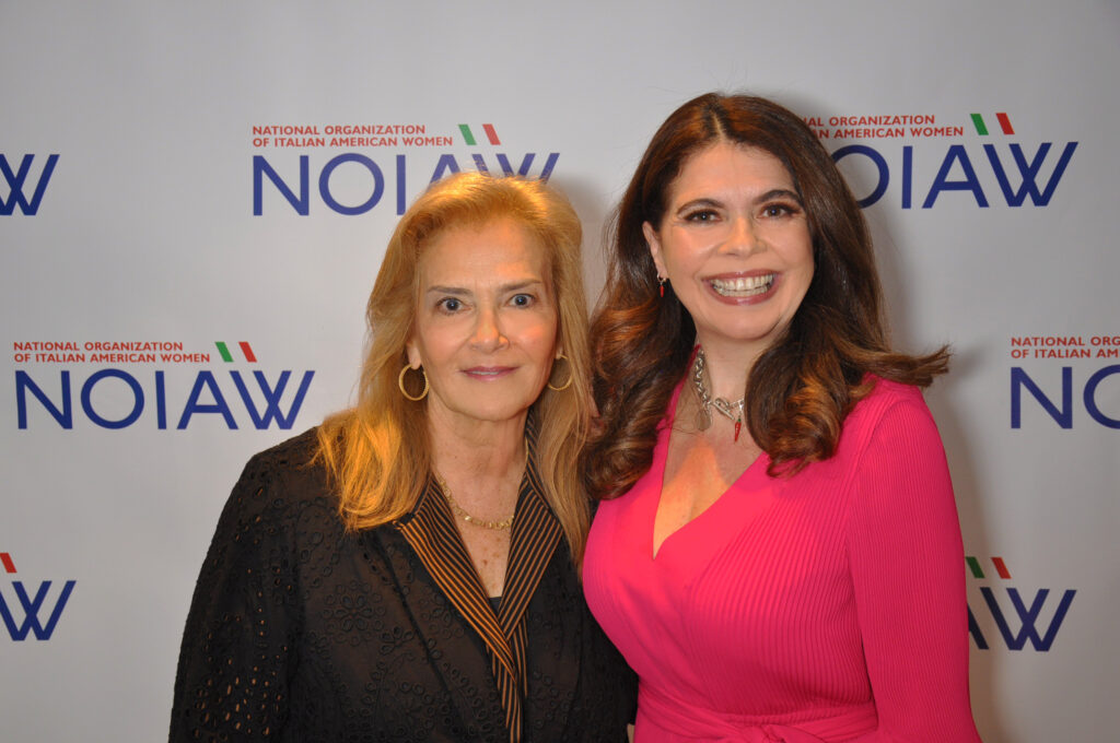 The two 2024 NOIAW honorees, Jodi Pulice and Ornella Fado. Jodi is a blonde woman, long haired, and dressed in black. Ornella has brown long hair, and she wears a pink dress